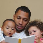 dad reading a book to his children