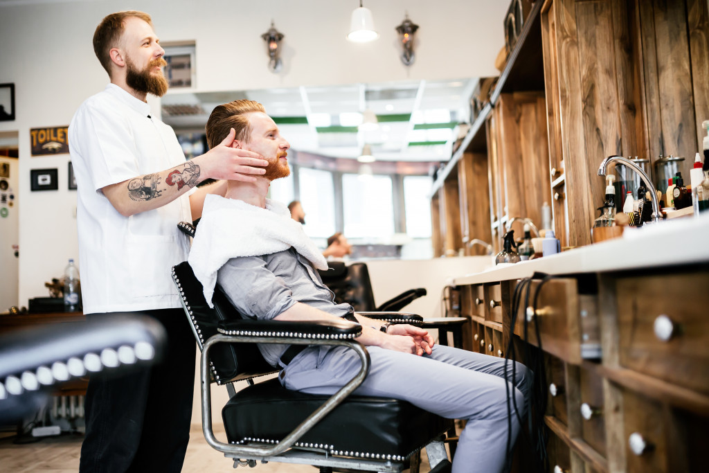 Young man having a mustache and beard treatment at a barber shop.