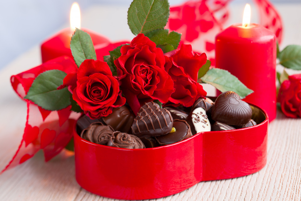 roses and chocolates in heart shaped box with candles