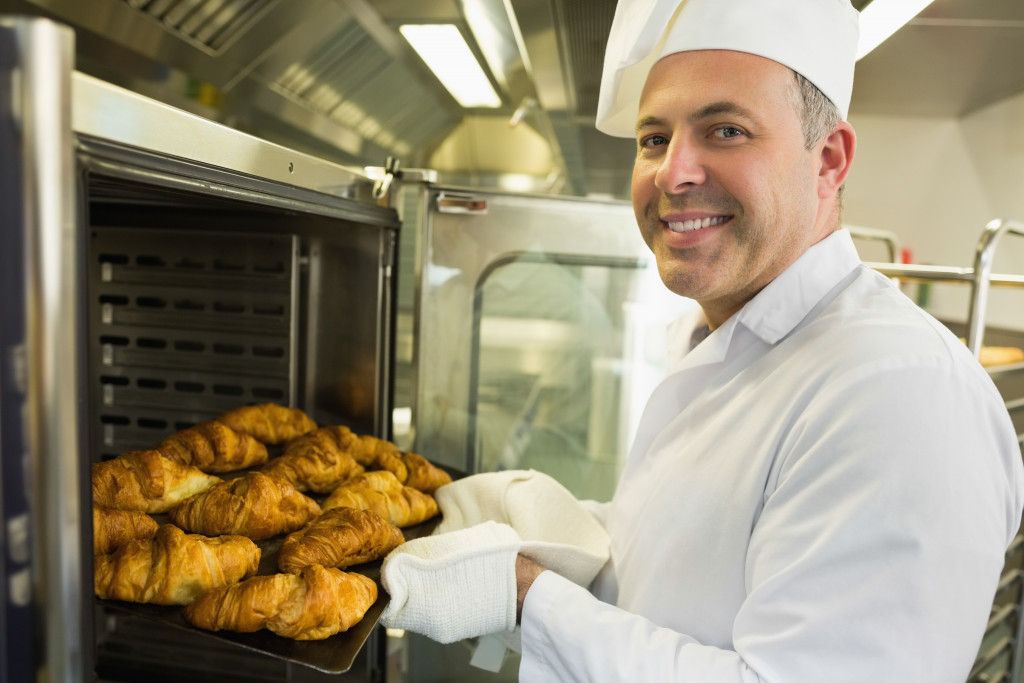 baker taking breads out from the oven