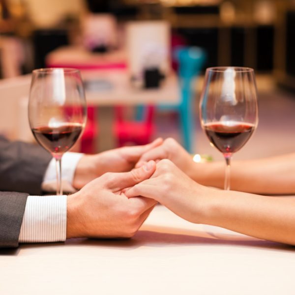 man and woman holding hands in restaurant