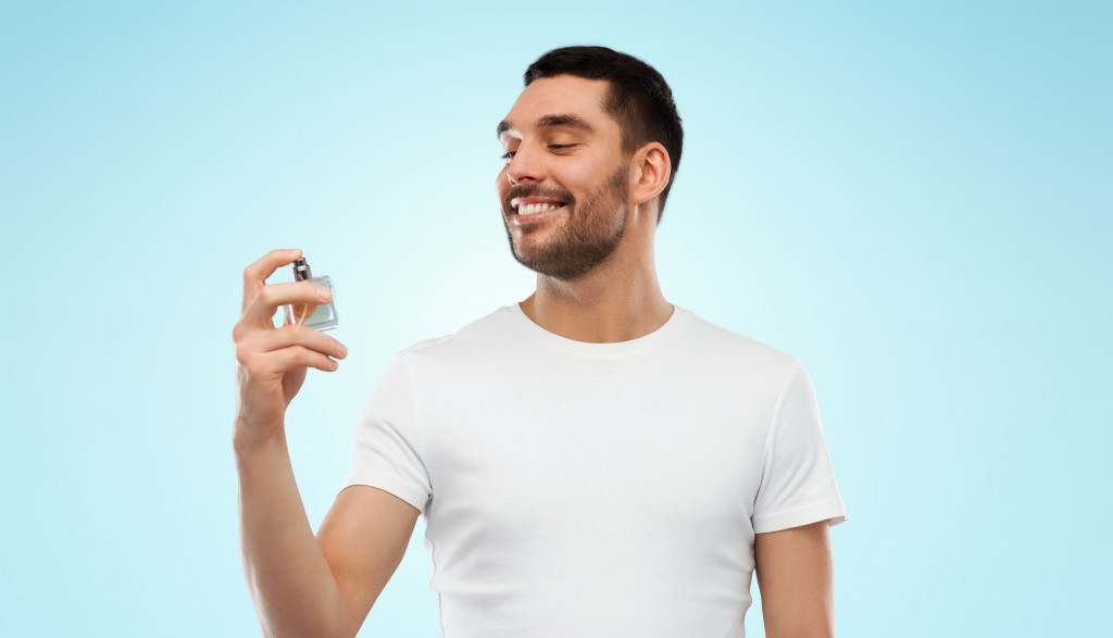 happy smiling young man with male perfume