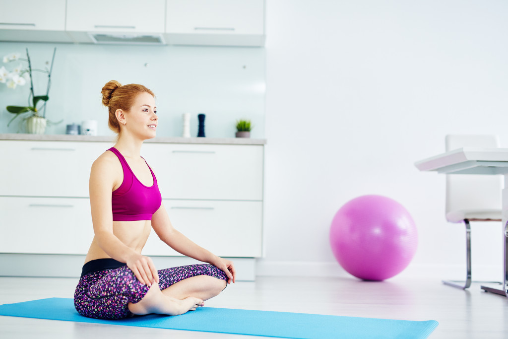 Young woman performing a yoga exercise at home.