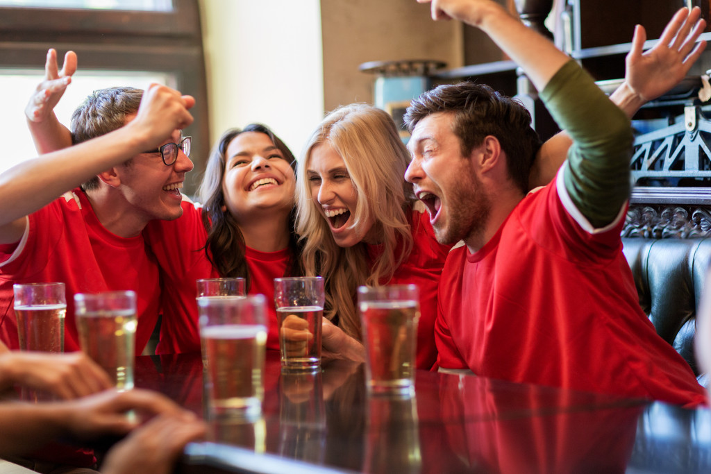 sports bar with friends wearing red and cheering